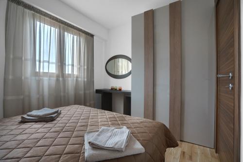 um quarto com uma cama com um espelho e uma janela em Apartments LORA Jadranskij put em Budva