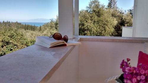 a book sitting on a window sill with a book at Villa Fedrita in Acharavi