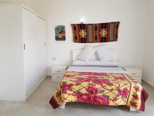 a bedroom with a bed with a colorful blanket at Luxor VIP Apartments in Luxor