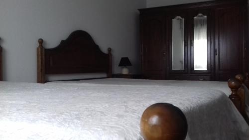 a bedroom with a large bed with a wooden headboard at Residencial Retiro Sra. da Luz in Ponte de Lima