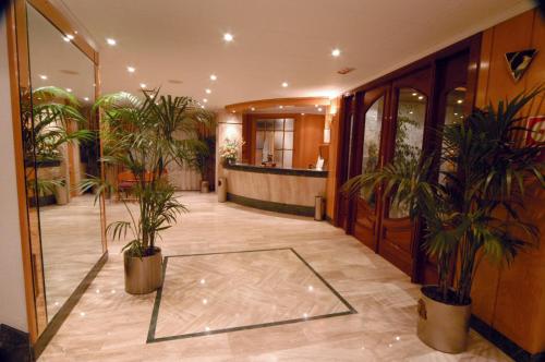 un hall avec des plantes en pot dans un bâtiment dans l'établissement Hotel Tanit, à Benidorm