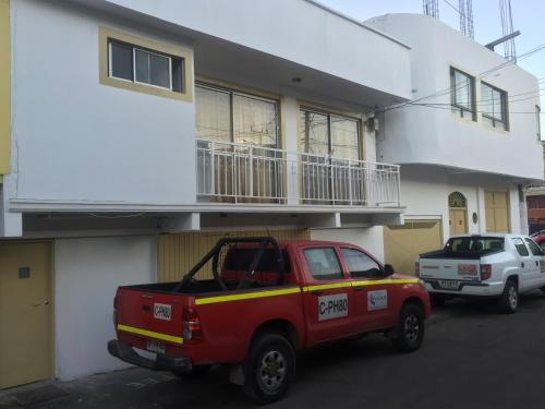 een rode vrachtwagen geparkeerd voor een gebouw bij Hotel Veas in Antofagasta