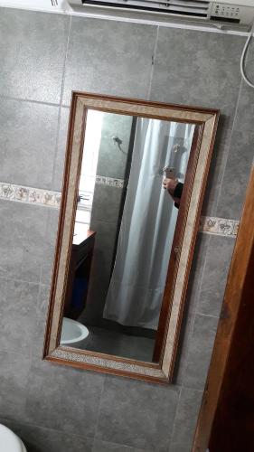 a mirror in a bathroom with a person taking a picture at Alojamiento Cba Observatorio in Córdoba