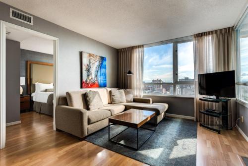 a living room filled with furniture and a tv at Carmana Plaza in Vancouver