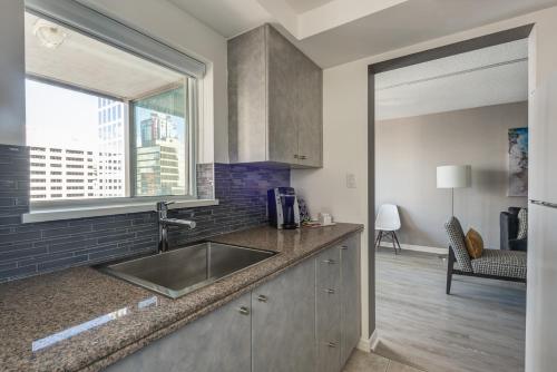 a kitchen with a sink and a window at Carmana Hotel & Suites in Vancouver