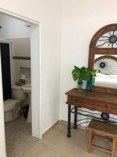 a bathroom with a toilet and a table with a mirror at Condo Mar Arena in Playa del Carmen