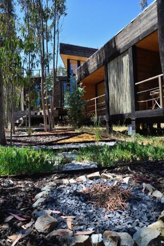 a house with a stone path in front of it at Tripanko Lodge & Bungalows in Pichilemu