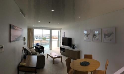 
a living room filled with furniture and a large window at Wallaroo Marina Waterfront Luxe Apartment in Wallaroo
