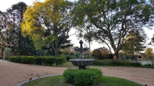 a fountain in the middle of a park with trees at Blair Athol Homestead in Inverell