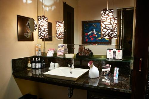 eine Badezimmerablage mit Waschbecken und Spiegel in der Unterkunft HOTEL MYTH M -ホテル マイス エム- Adult Only in Sennan