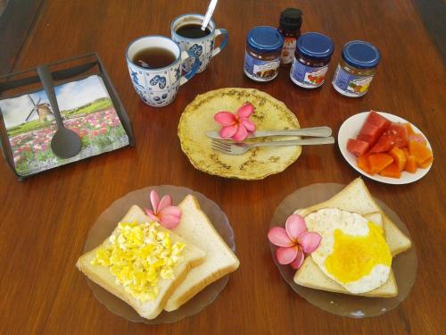 una mesa de madera cubierta con platos de desayuno en Indah Homestay and Cooking classes, en Senggigi 
