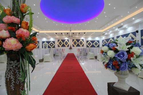 a banquet hall with a red carpet and flowers at Nonghan Grand Hotel and Resort in Nong Han