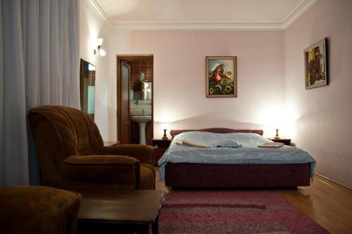 1 dormitorio con 1 cama y 1 silla en Casanova Inn - Boutique Hotel, en Dilijan