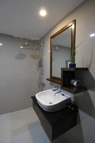 a bathroom with a sink and a mirror and a shower at Nonghan Grand Hotel and Resort in Nong Han