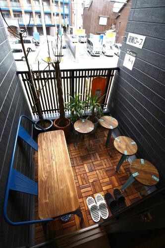a balcony with tables and chairs on a balcony at Nekokura Hostel in Fukuoka