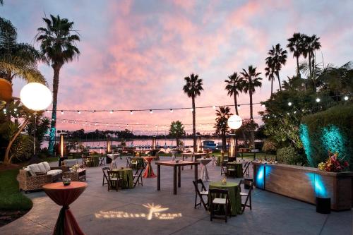 a patio with tables and chairs and palm trees at Paradise Point Resort & Spa in San Diego