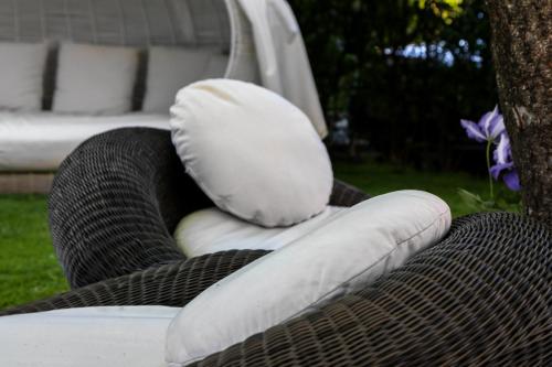 two pillows sitting on top of a wicker chair at Hotel Villa Groff in Ora/Auer