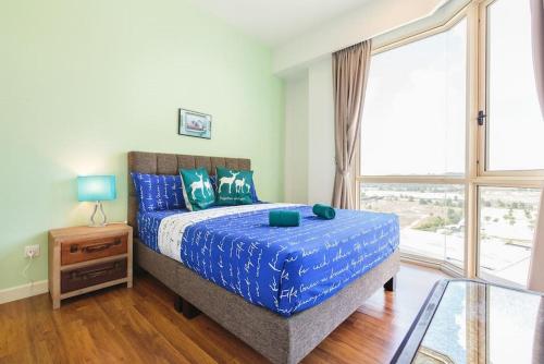 ヌサジャヤにあるHostaHome Suites at Afiniti Residence walk to Legolandのベッドと大きな窓のある寝室