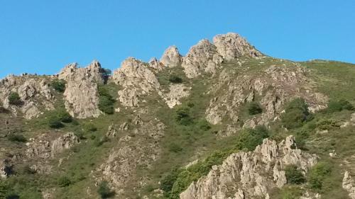 a rocky mountain with trees on top of it at Les maisonnettes de bonneval in Jaujac