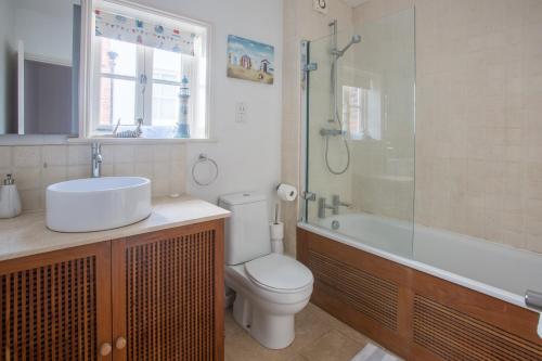 y baño con aseo, lavabo y ducha. en Pugwash en Aldeburgh