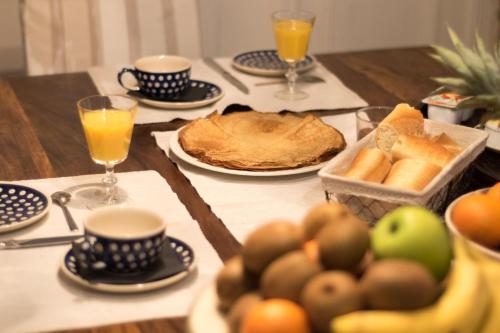 une table recouverte de assiettes de pain et de tasses de jus d'orange dans l'établissement Les Chambres de Lourmel, à Pontivy