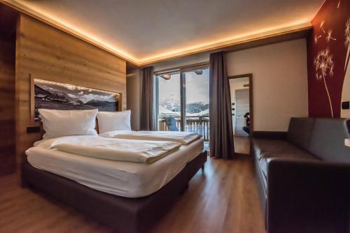 a hotel room with a large bed and a couch at Hotel Le Alpi in Livigno