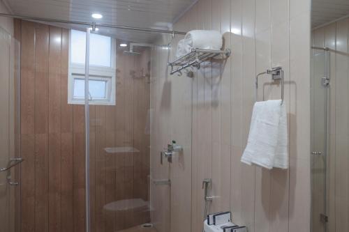 baño con ducha y puerta de cristal en Jai Hotels en Darjeeling