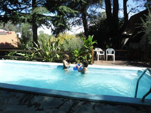 two children playing in a swimming pool at Cabañas Ñuke Mapu in Villa Ventana