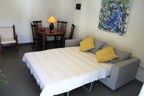 Apartment SEA VIEW in front of the beach of Agia Marina في بورتو رافتي: غرفة معيشة مع أريكة مع وسائد صفراء