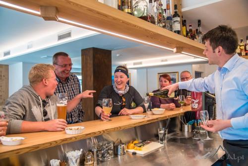 a group of people sitting at a bar at Hotel Le Alpi in Livigno