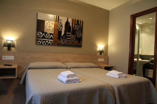 a bedroom with two towels on a bed at Hostal Acella in Pamplona