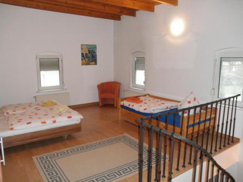ein Wohnzimmer mit 2 Betten und einer Treppe in der Unterkunft Apartment-Ferienwohnung Dresden-Briesnitz in Dresden
