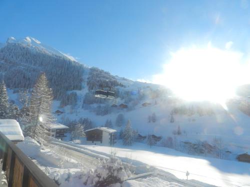 a snow covered mountain with trees and a ski slope at Chalet-Hôtel du Borderan in La Clusaz