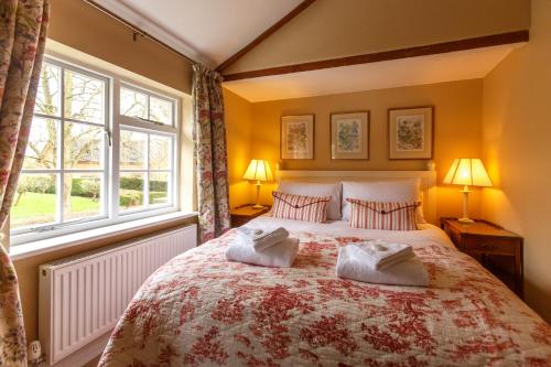 a bedroom with a large bed with two pillows at Jasmine Cottage in Kelsale