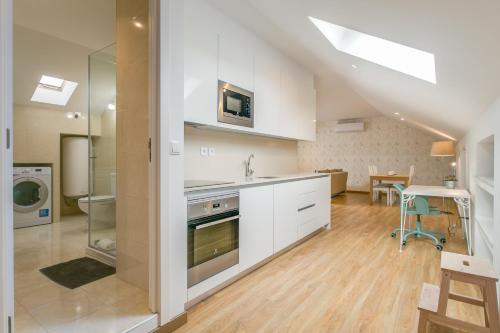 a kitchen with white cabinets and a stove top oven at Home Out Rooms & Apartments in Lisbon