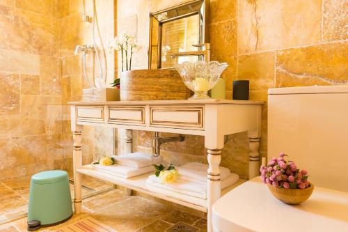 La salle de bains est pourvue d'un lavabo et d'une table avec des serviettes. dans l'établissement Country Spa Retreat, à Snagov