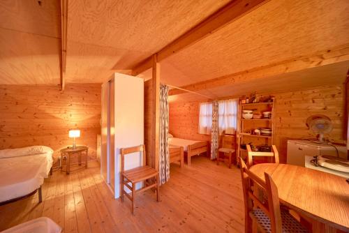 Zimmer mit einem Bett und einem Tisch in einer Hütte in der Unterkunft Camping Escana in Es Cana