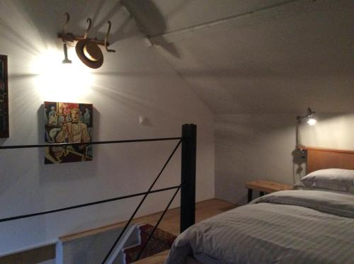 - une chambre avec un lit et une lumière sur le mur dans l'établissement Manoir de La Muette, à Isneauville