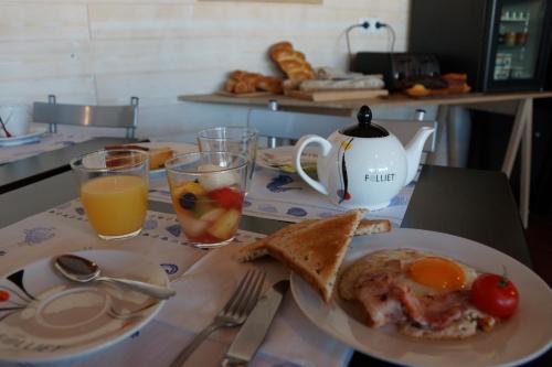 a breakfast table with a plate of eggs and toast at Hotel La Cote Oceane- Bureau- 250 m plage in Saint-Jean-de-Monts