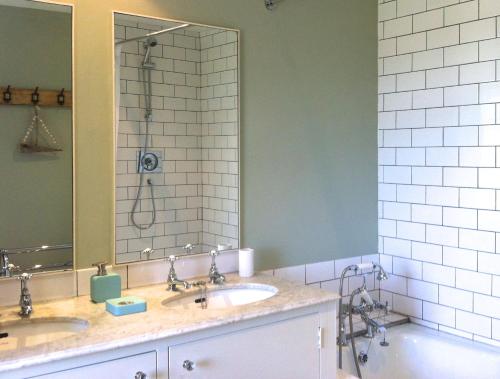 a bathroom with two sinks and a shower and a tub at Seakale Cottage in Rye Harbour