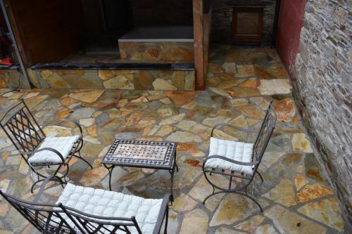 a group of chairs and a table on a stone floor at Isabel Artemis ES in San Tirso de Abres