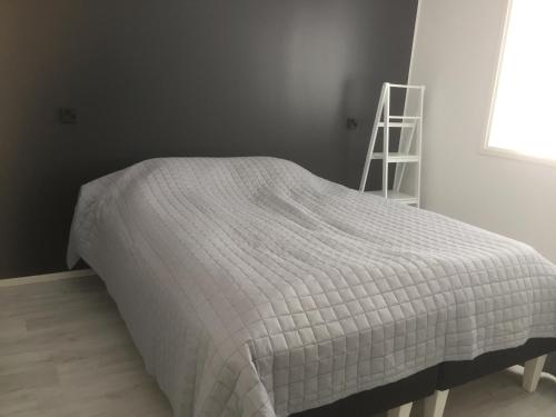 ein Bett mit einer weißen Bettdecke in einem Schlafzimmer in der Unterkunft Aurora Apartment Inari in Inari