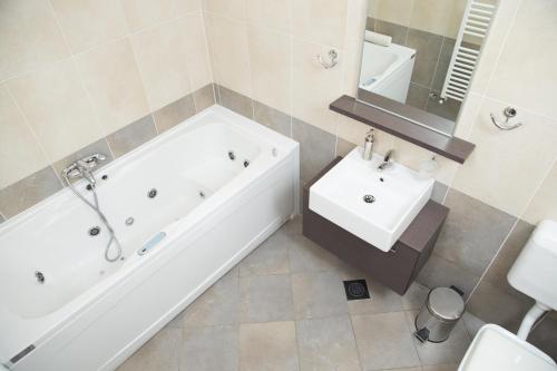 a bathroom with a white tub and a sink at Zoi Apartments in Dobrovo