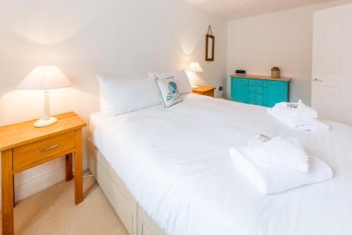 a bedroom with two beds and a night stand with a lamp at The Lobster Pot in Aldeburgh