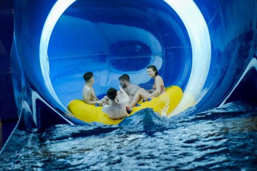a group of boys riding on a raft in a water tunnel at Crows Nest Caravan Park in Filey