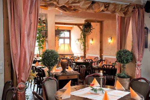 a restaurant with tables and chairs and a lamp at Landgasthof Eschbacher Katz in Usingen