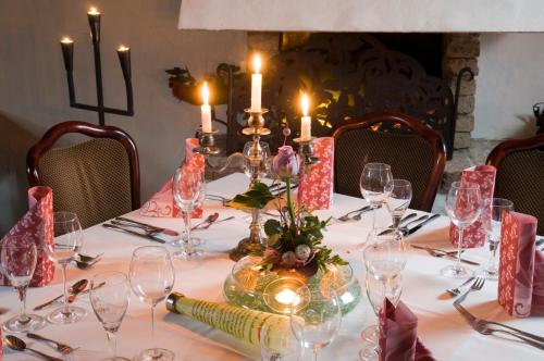 a table with candles and wine glasses on it at Landgasthof Eschbacher Katz in Usingen