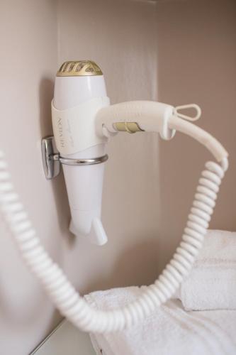 a hair dryer is attached to a wall at Hotel Saraceno Resort with Private Beach in Milano Marittima