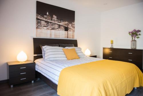1 Schlafzimmer mit einem Bett mit gelber Bettdecke und 2 Lampen in der Unterkunft Casa Terramar in Sesimbra