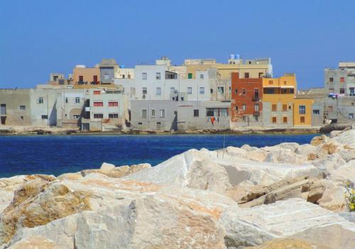 un gruppo di edifici sull'acqua con rocce di Trapani Centro Little Home a Trapani